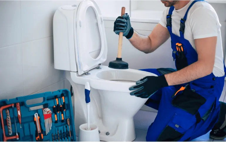 Plumber unclogging a toilet in a residential bathroom – Professional home plumbing services in San Antonio, TX by 2nd Opinion Plumbing.