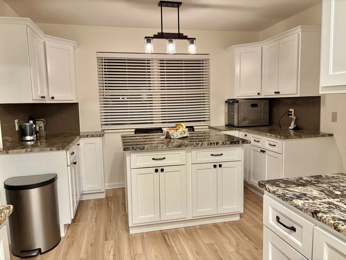 Bright renovated kitchen with shaker cabinets and granite countertops