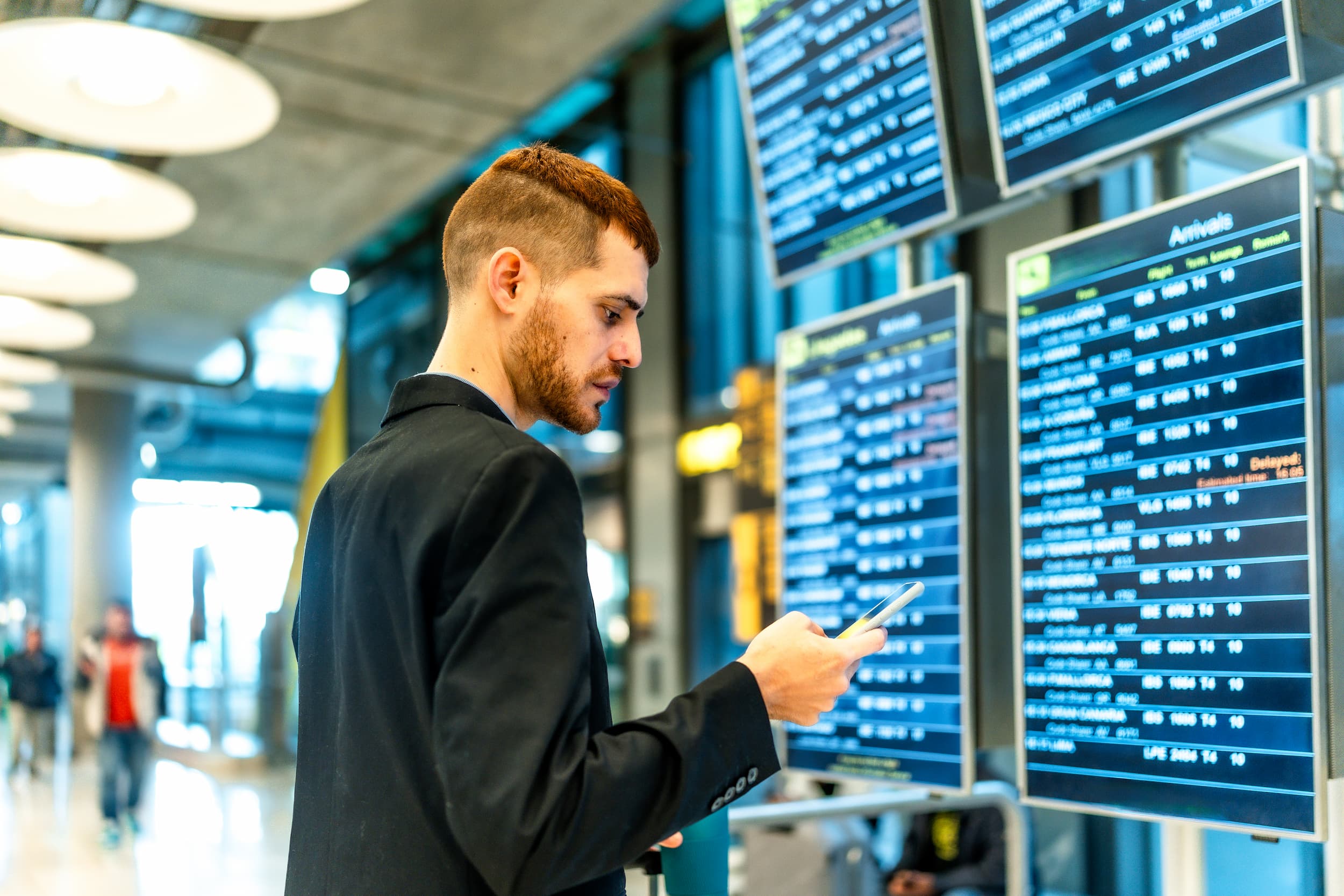 Pasajero revisando su itinerario de vuelo en el aeropuerto.