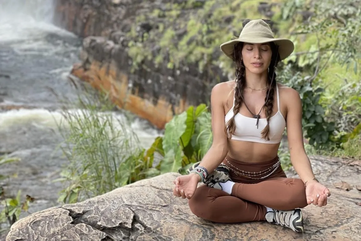 a woman digging in the sand with a stick