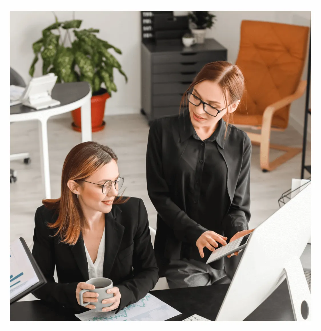 Two business women discussing financials.