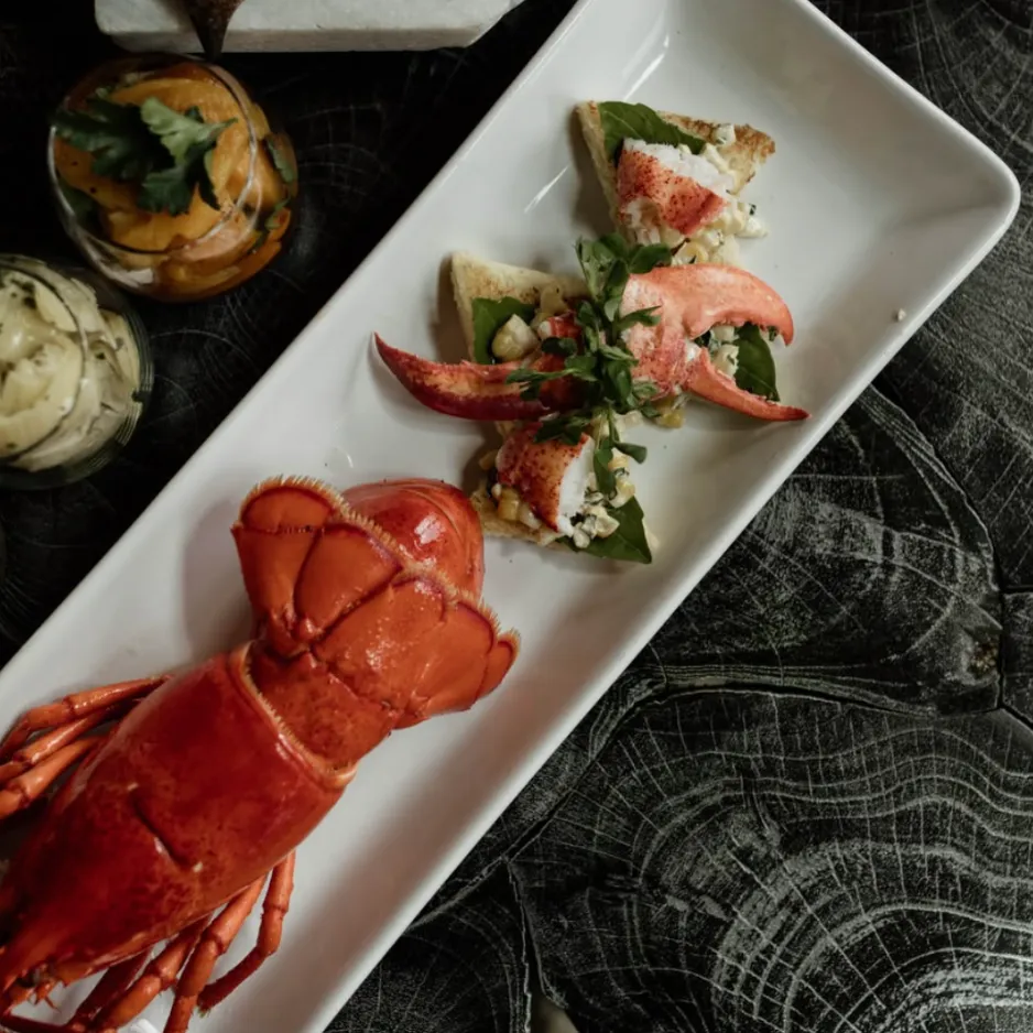 A freshly prepared Maine lobster tail and claw appetizer plate, highlighting local, seasonal ingredients from a private chef.
