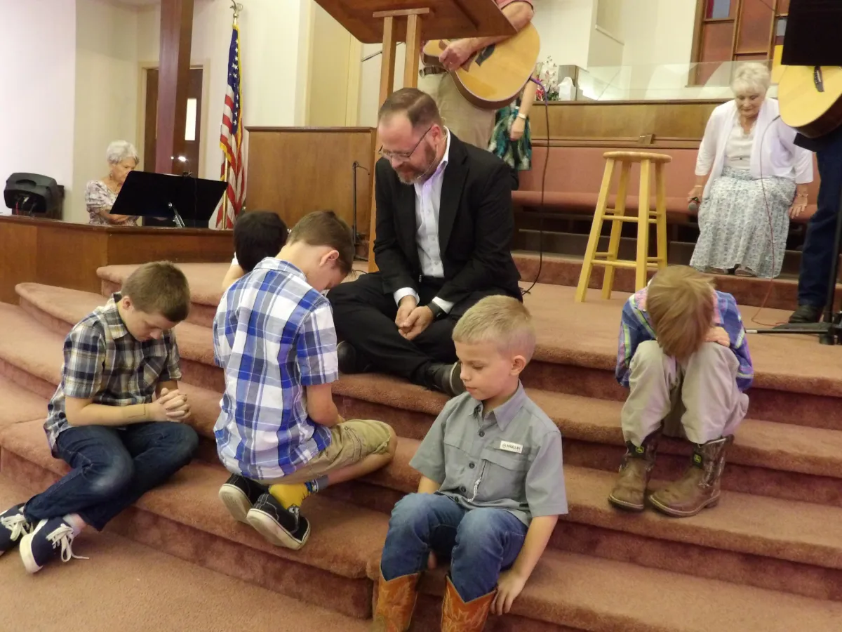 boy in blue and black polo shirt standing beside boy in blue and orange t-shirt