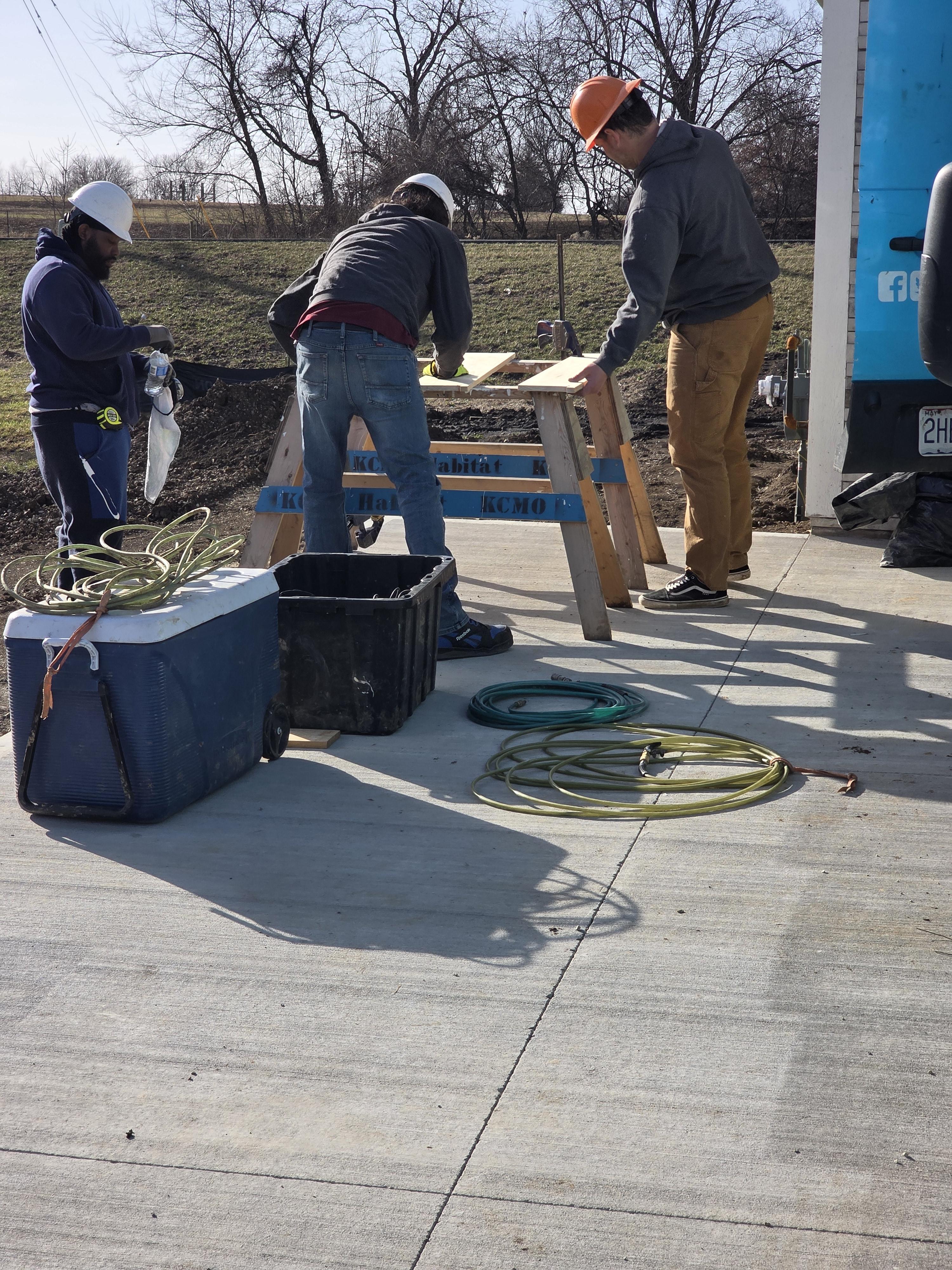 Minority contractors reviewing blueprints on a construction table