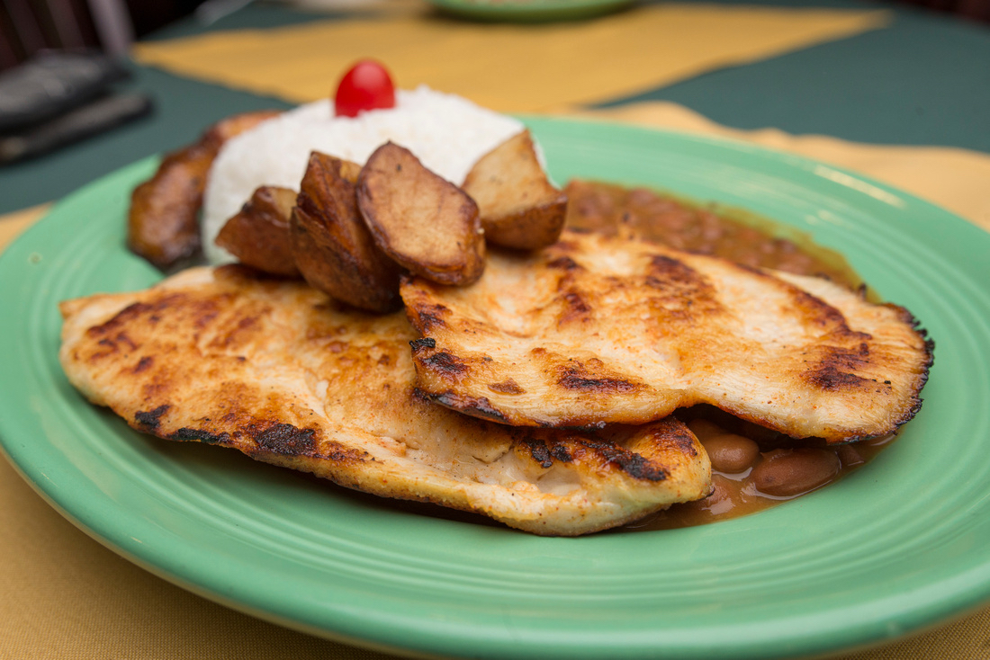 Avocado and pepper garnish on a sizzling steak fajita with cilantro, studio-lit.