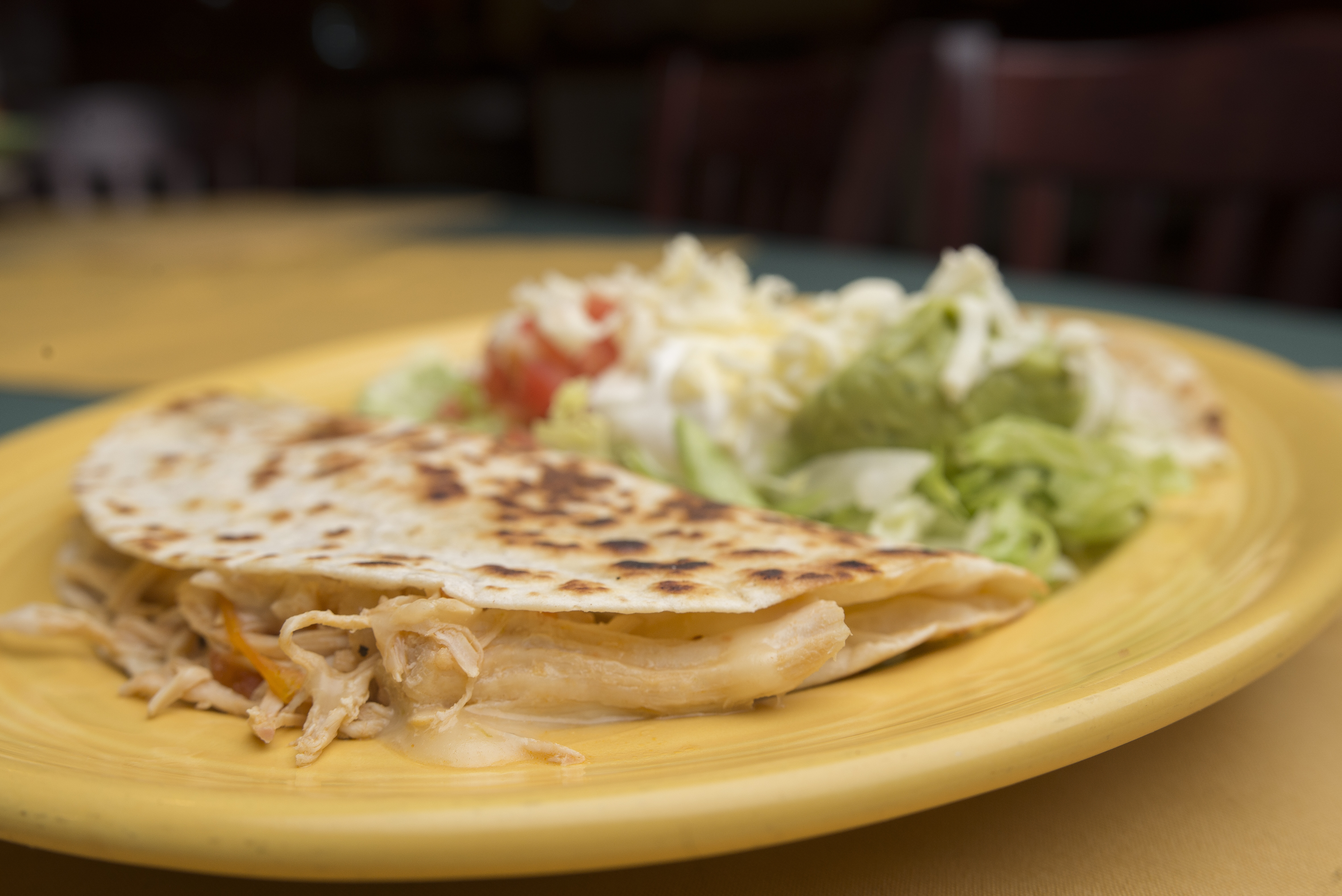 Overhead shot of a family table sharing fajita platters, rustic tableware, hands reaching for tortillas.