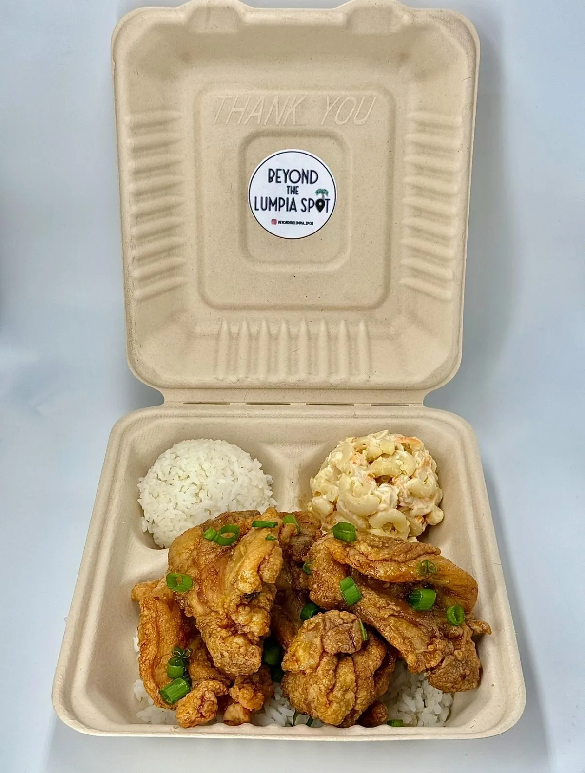 A stack of fluffy Ube Pancakes with a vivid purple hue, drizzled with coconut sauce and sprinkled with toasted coconut flakes, presented on a pastel plate with a tropical napkin and utensils.