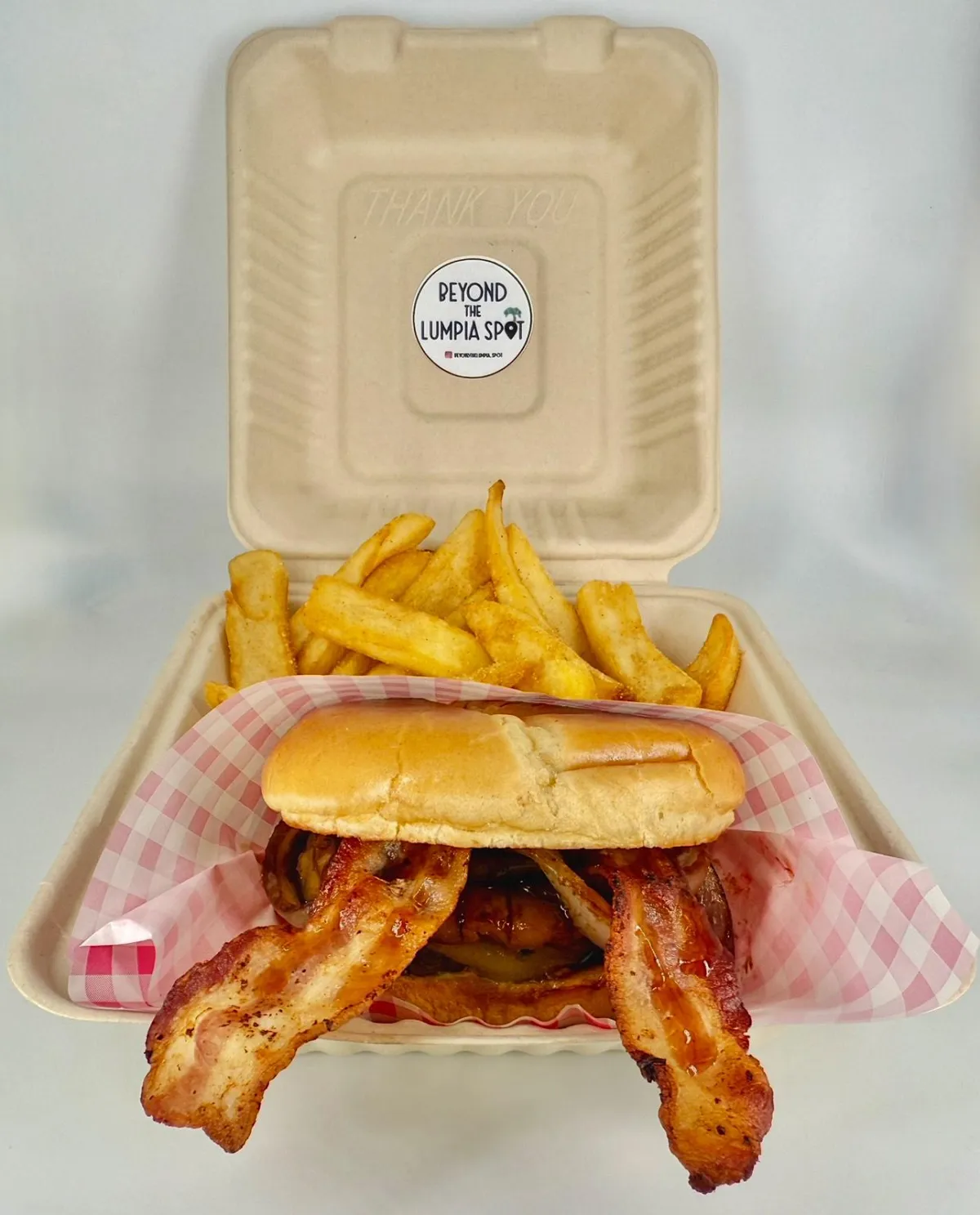 Three soft tortillas filled with sizzling pork sisig, topped with bright mango salsa and fresh cilantro, arranged on a rustic board with lime wedges and a palm leaf accent in the background.