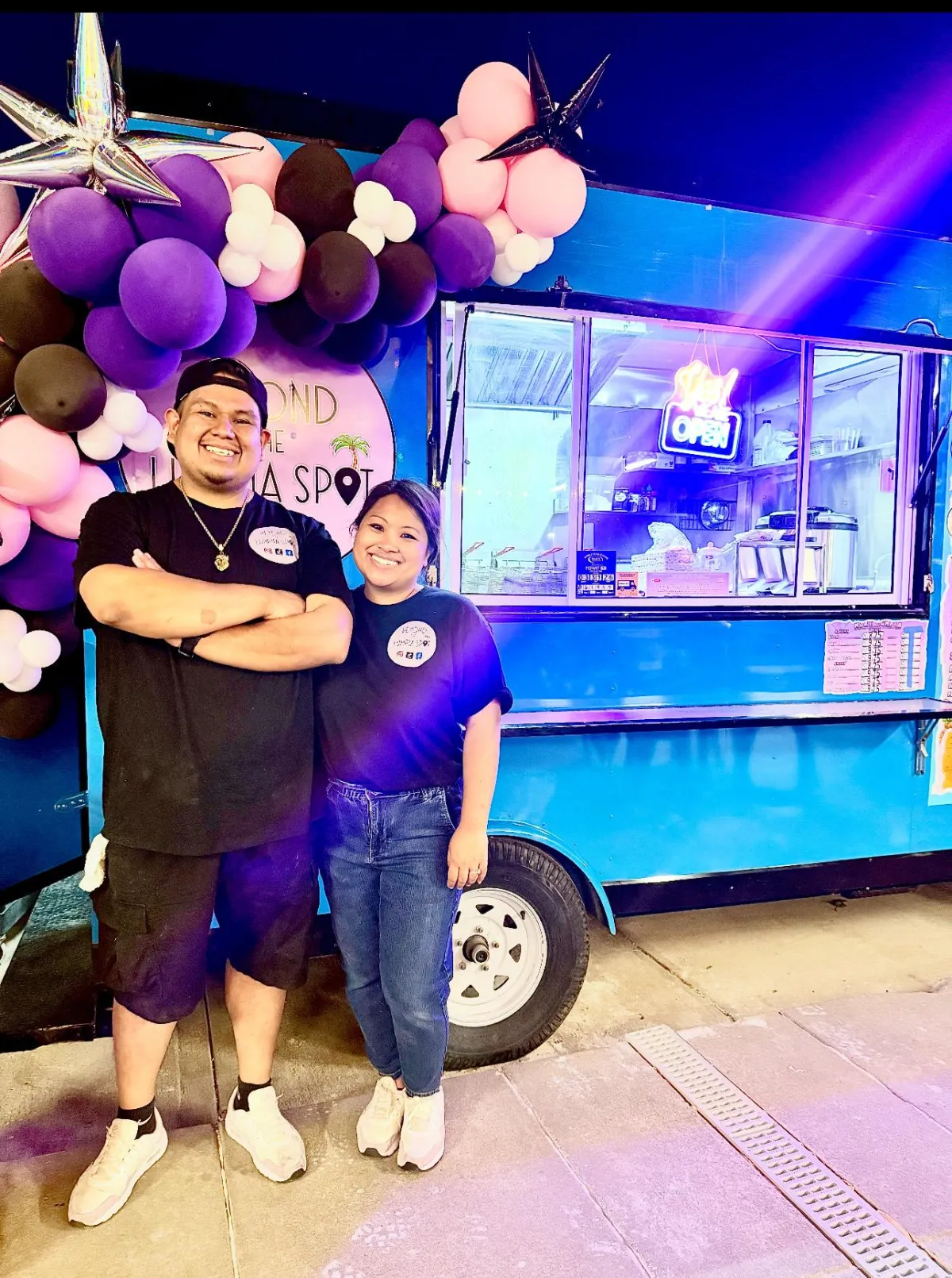 Founders preparing Filipino fusion dishes in a food truck kitchen, smiling, tropical decor visible