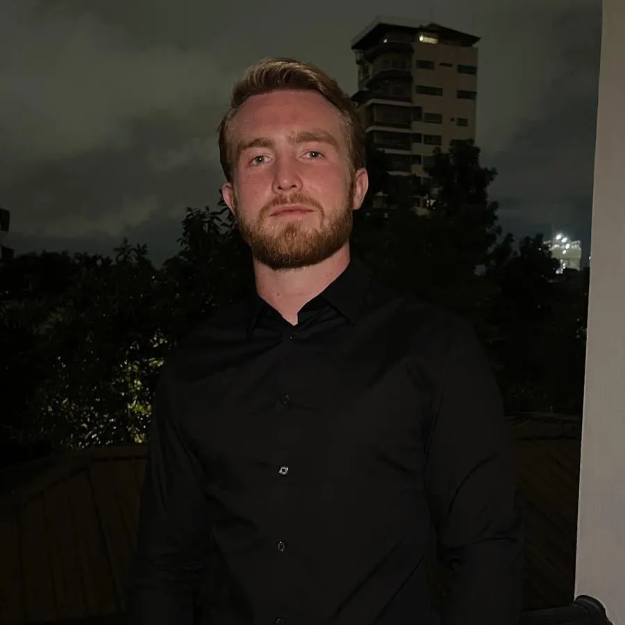 Real Estate Manager standing in front of a tall block building