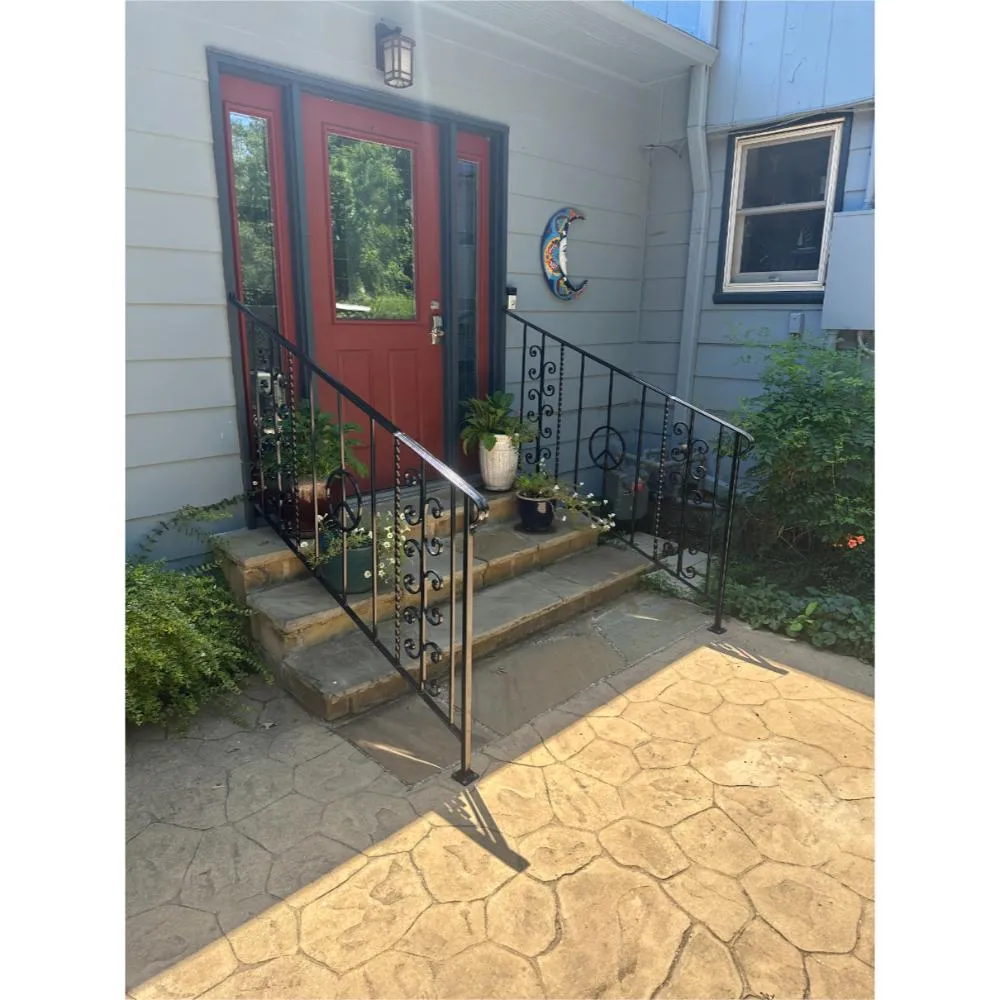 Welded steel porch railings with decorative scrolls — entry steps.