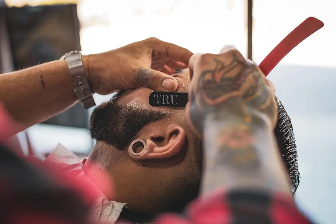a man cutting another mans hair in a barber shop