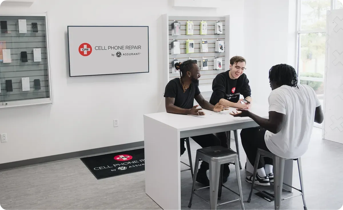 Customers talking with a technician at CPR Cell Phone Repair