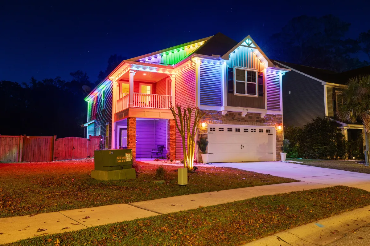 Residential home lit with multi-colored EverBright permanent LED roofline lights for a bold and festive appearance.