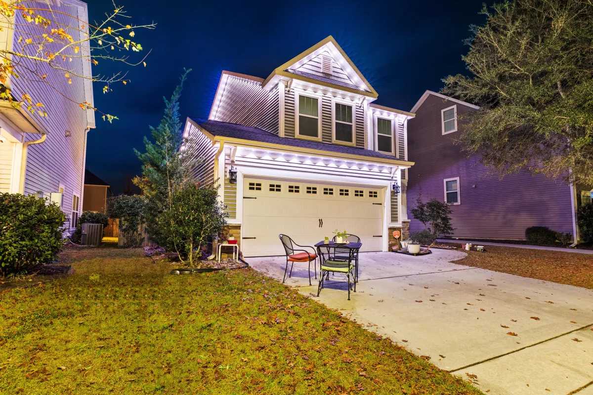 Two-story house with warm white EverBright permanent holiday lighting highlighting the roofline.