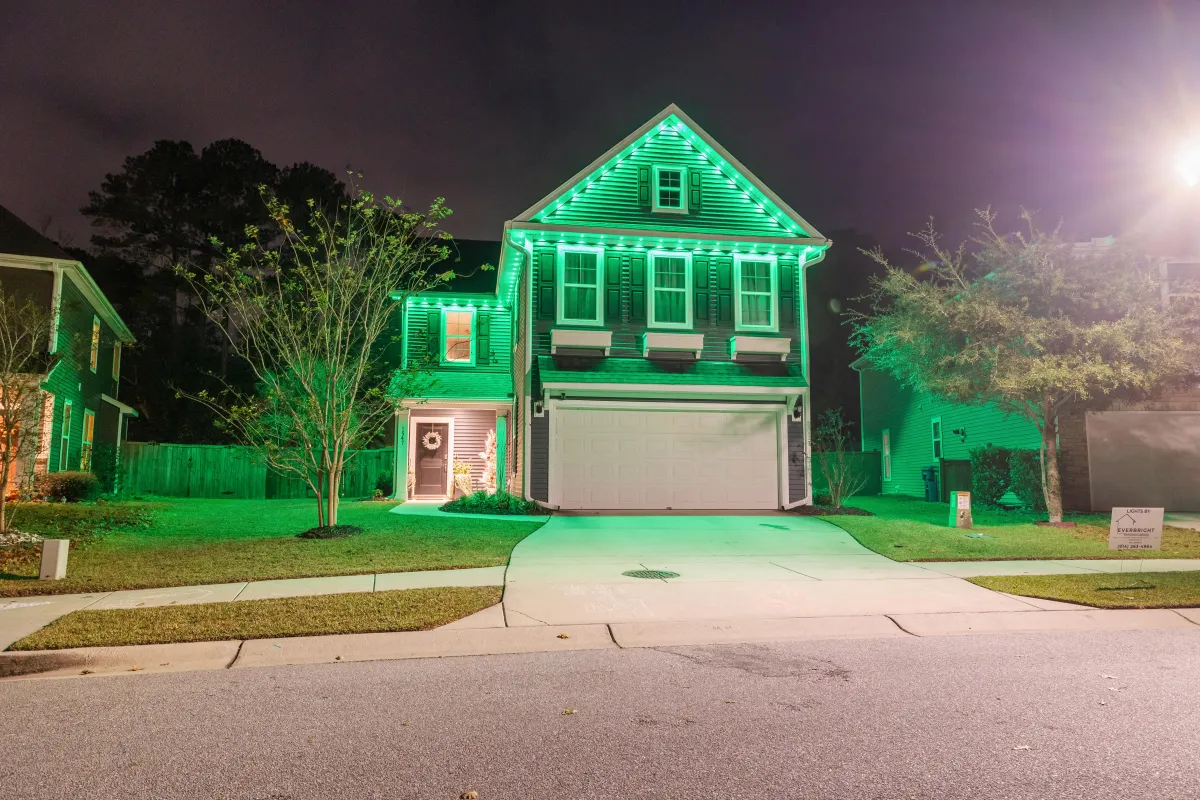 Green and white EverBright permanent LED lighting on a two-story house, showcasing energy-efficient holiday decor.