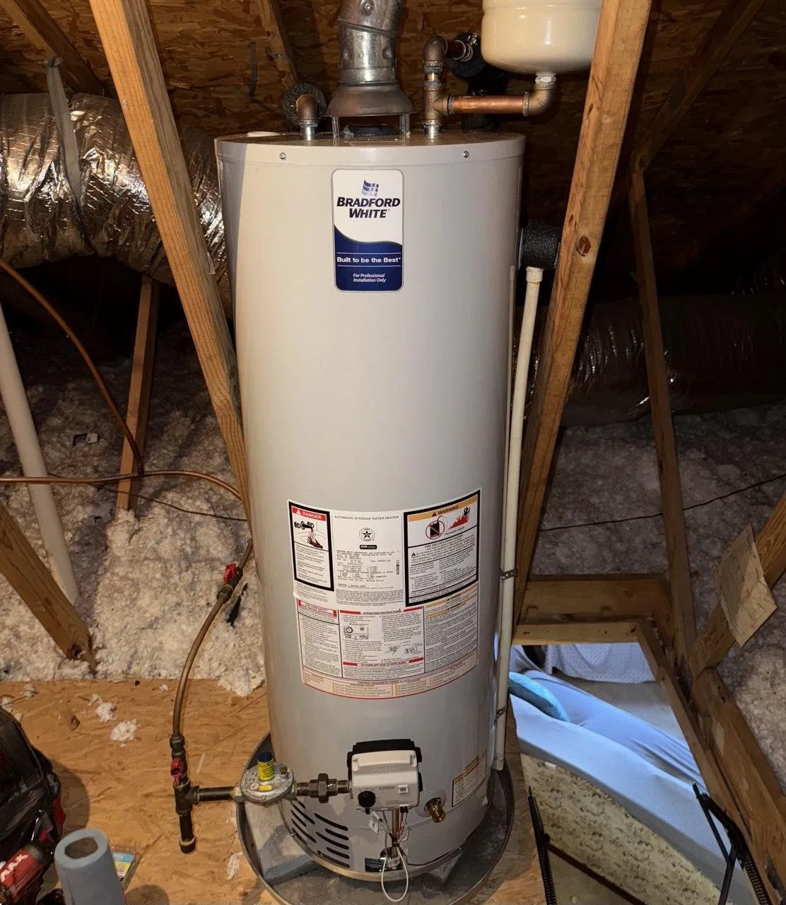 Bradford White water heater installed in attic with connected pipes