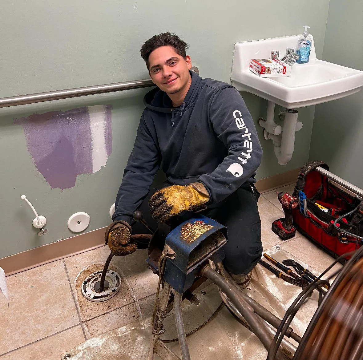 Elite Plumbing technician performing professional drain cleaning with specialized equipment