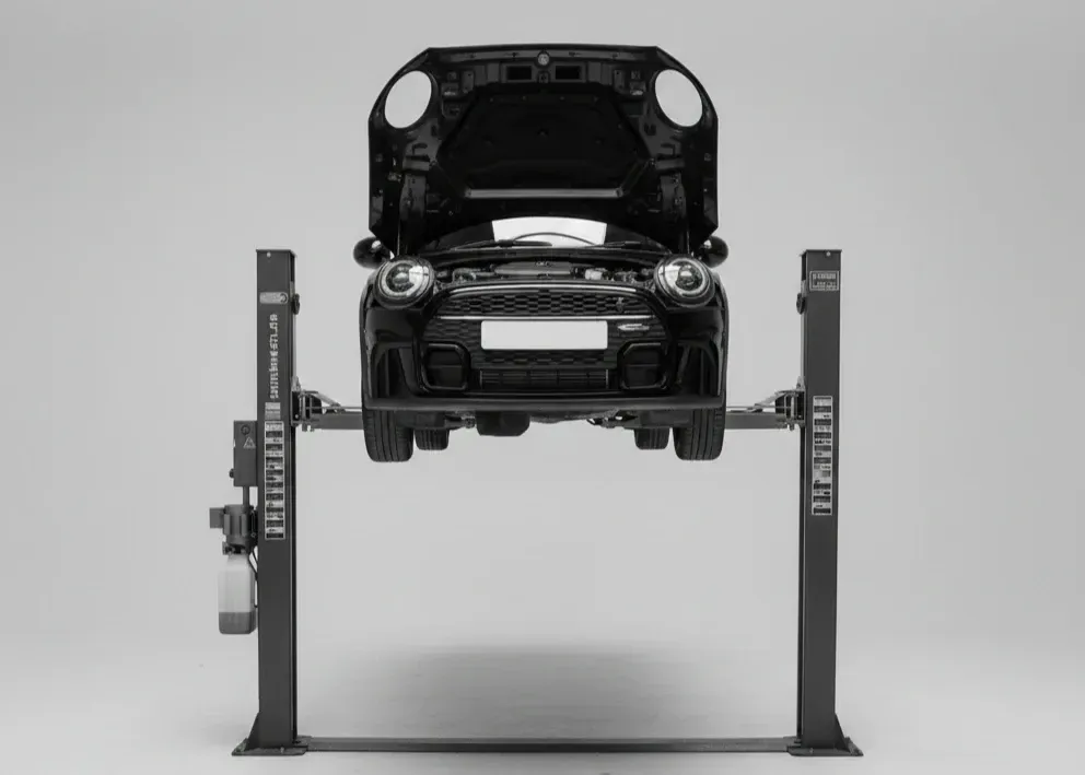 A black car face-on, on  2 post vehicle ramp