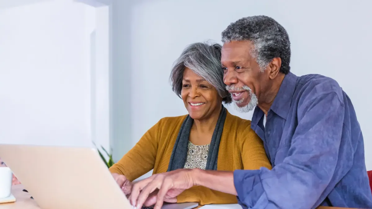 Senior couple looking together at a laptop