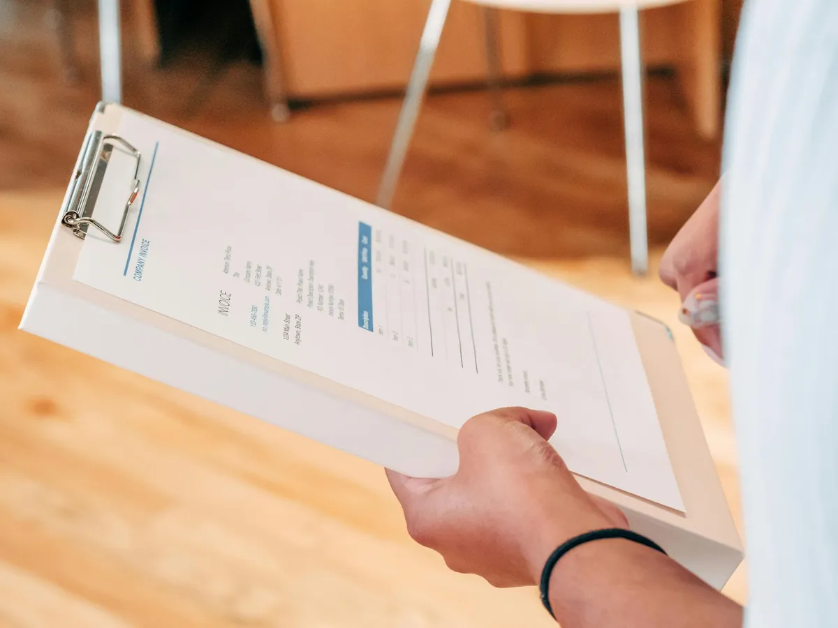 Hands holding a work order clipboard for a commercial repair job in Lubbock, TX