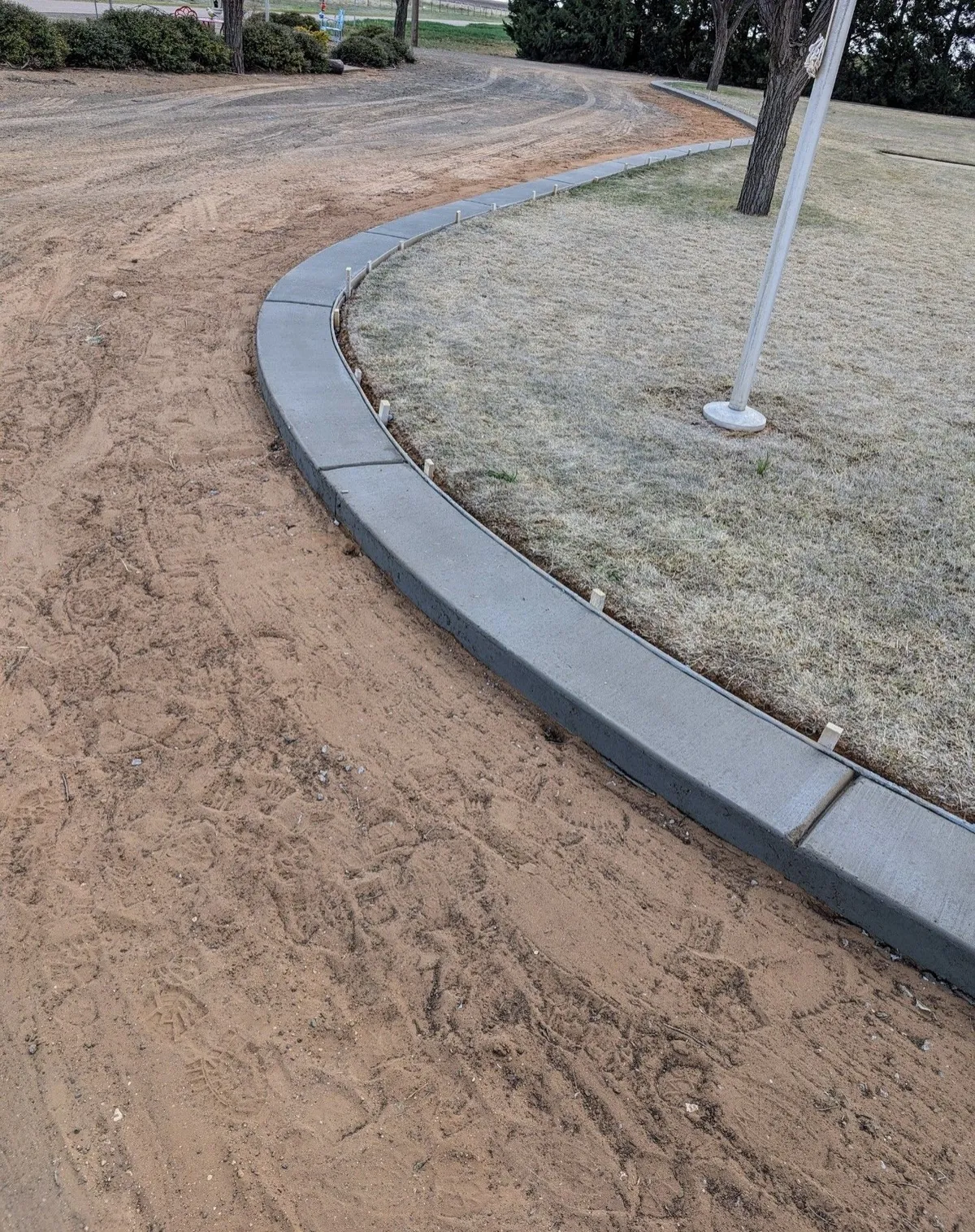Concrete curb curving around a landscaped island, commercial concrete repair in Lubbock, TX