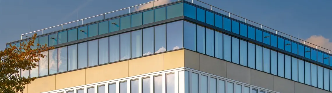 Tan commercial office building with bands of glass windows under a blue sky in Lubbock, TX