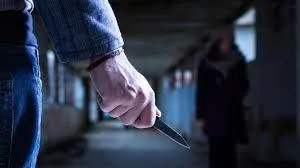Image of armed threat to woman used to stress real-world dangers and value of Krav Maga self-defense.