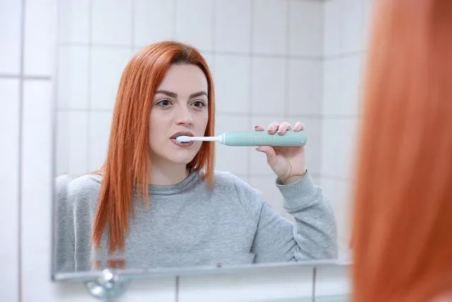 A girl brushing her teeth to illustrate the importance of habits