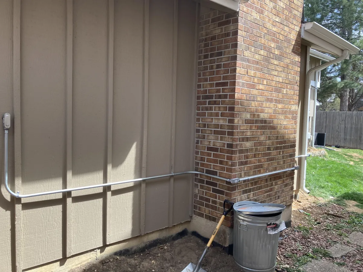 Electrician repairing exterior electrical wiring on home