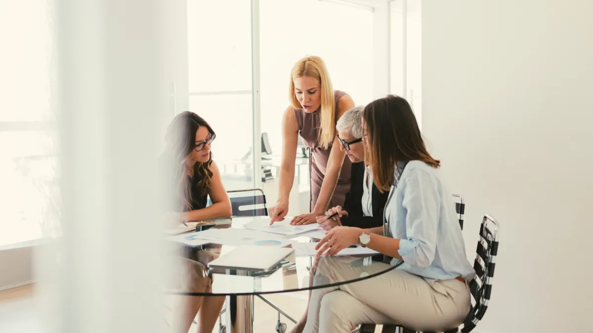 a group of women working together on business financial statements