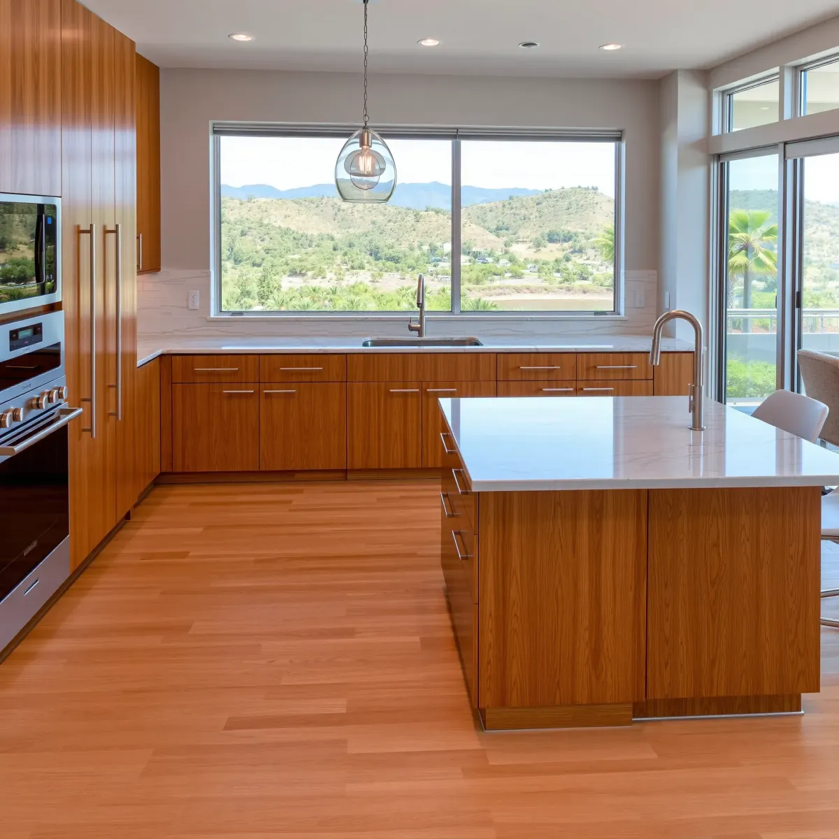 Remodeled Coto De Caza kitchen with modern wood cabinets, marble island, stainless appliances, and scenic hill views.