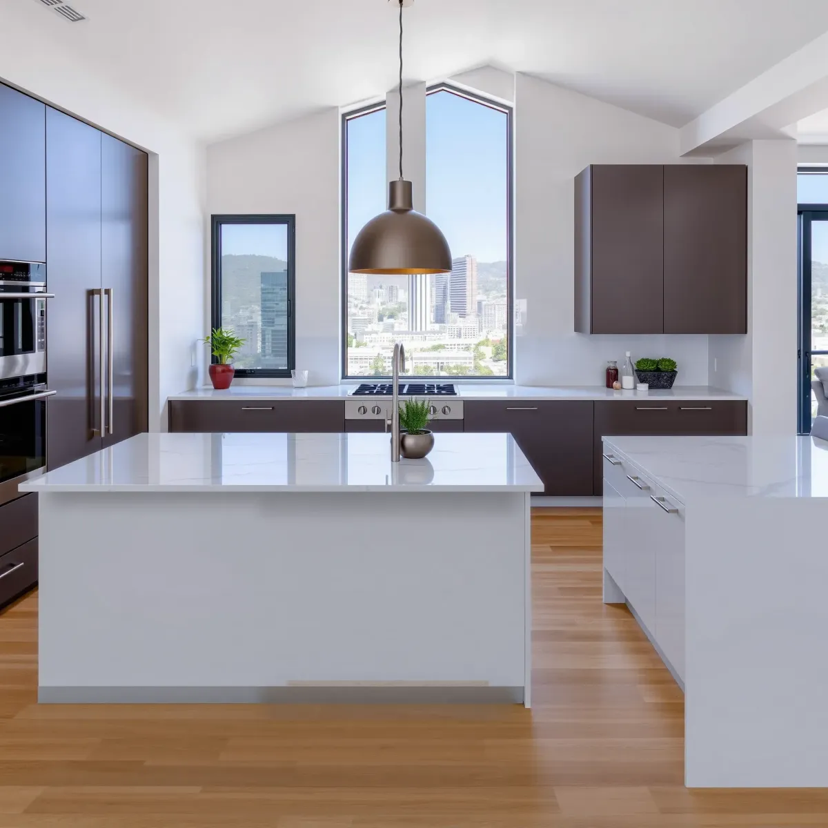 Modern Los Angeles kitchen with sleek cabinetry, stainless steel appliances, marble island, pendant lights, and city views.