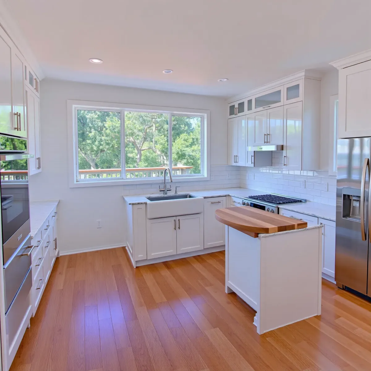Renovated Lacy, CA kitchen featuring modern neutral-tone cabinets, stainless steel appliances, quartz countertops, and hardwood floors.