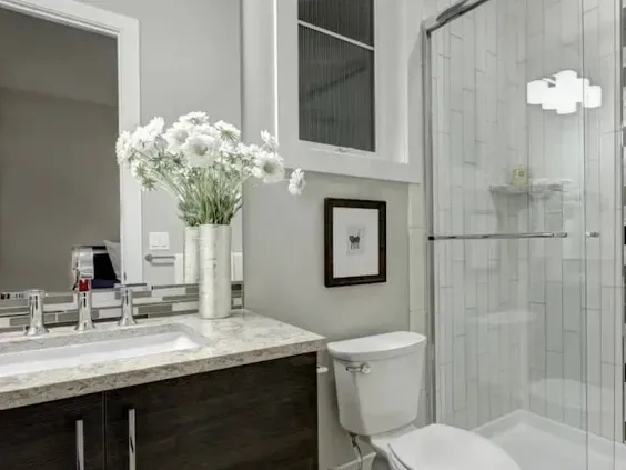 Renovated Los Angeles kitchen with marble countertops, stainless steel appliances, wooden cabinets, and sunlit open space.