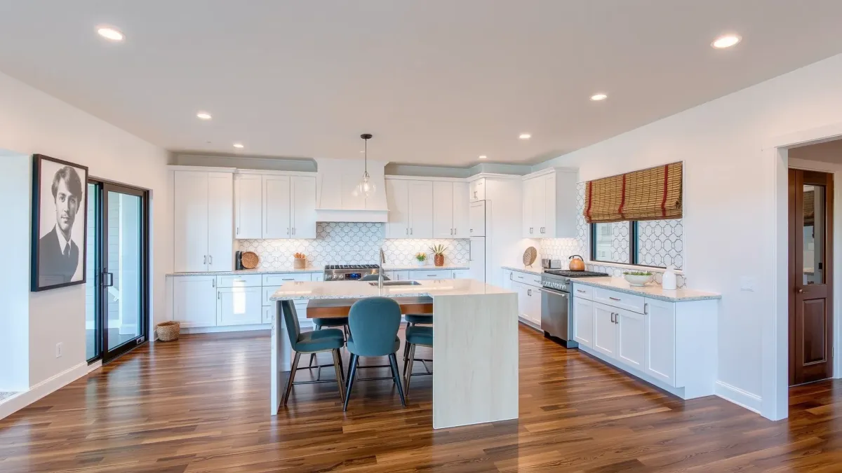 Beautifully renovated Windsor Village living room with modern design, hardwood floors, natural light, sleek furnishings, and open-plan kitchen.