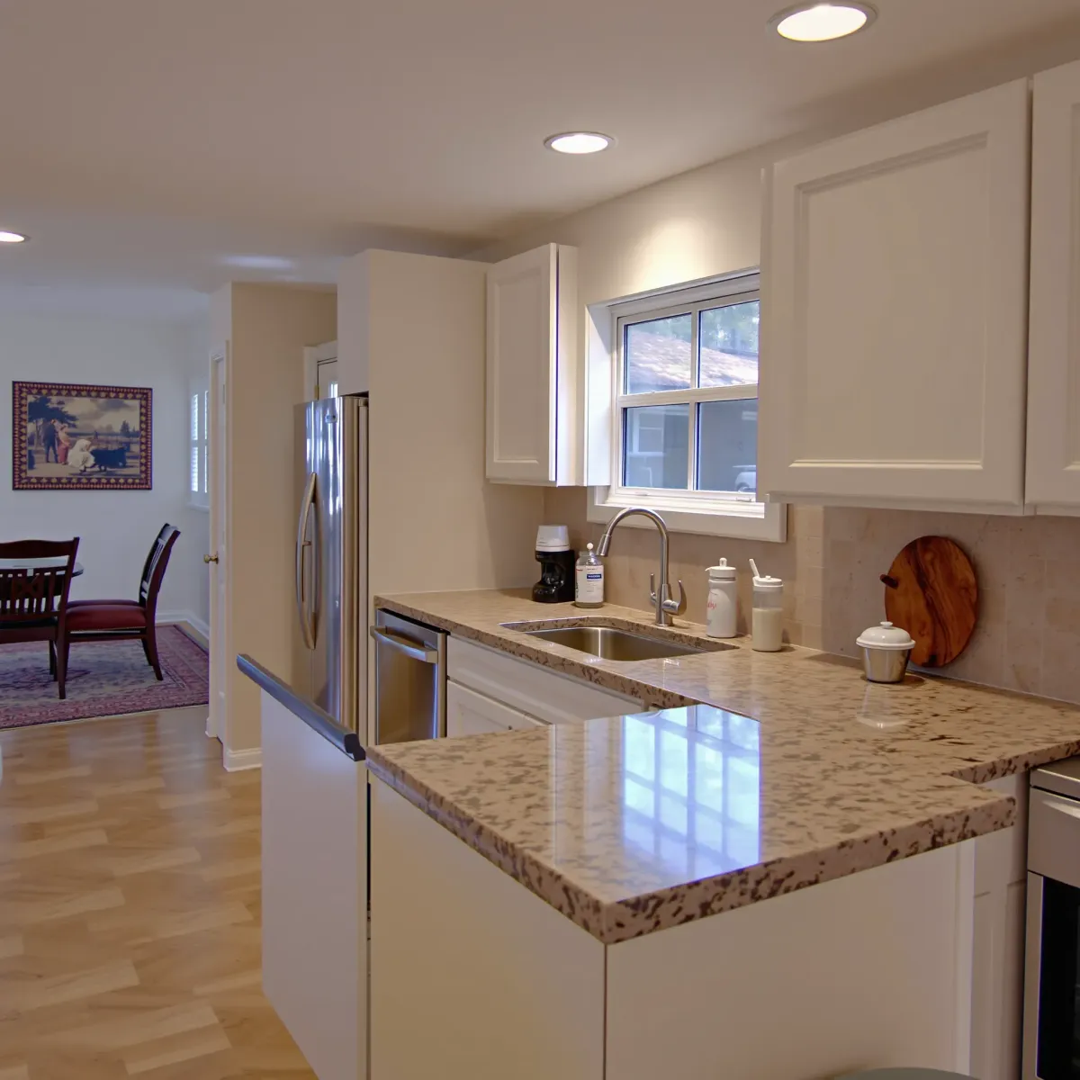 Remodeled Riverview East, CA kitchen with sleek matte cabinetry, granite island, stainless steel appliances, and natural light.