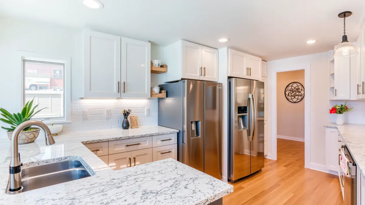 Remodeled Windsor Village kitchen with granite counters, stainless appliances, wooden cabinetry, hardwood floors, and natural light.