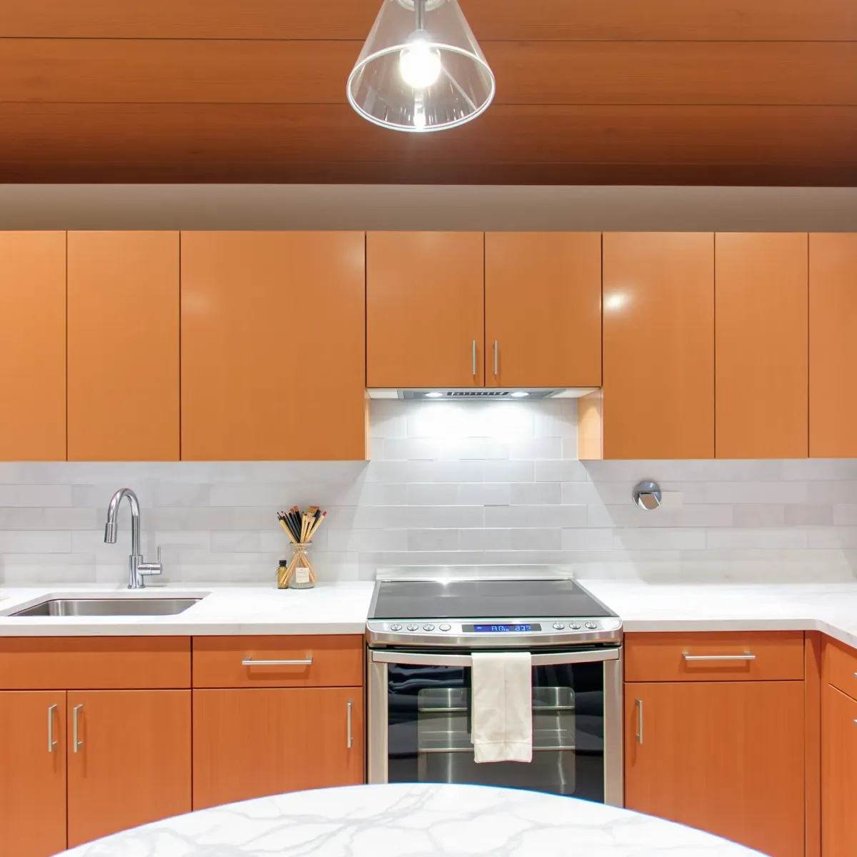 Modern kitchen with granite countertops, sleek cabinetry, stainless steel appliances, and bright, natural lighting.