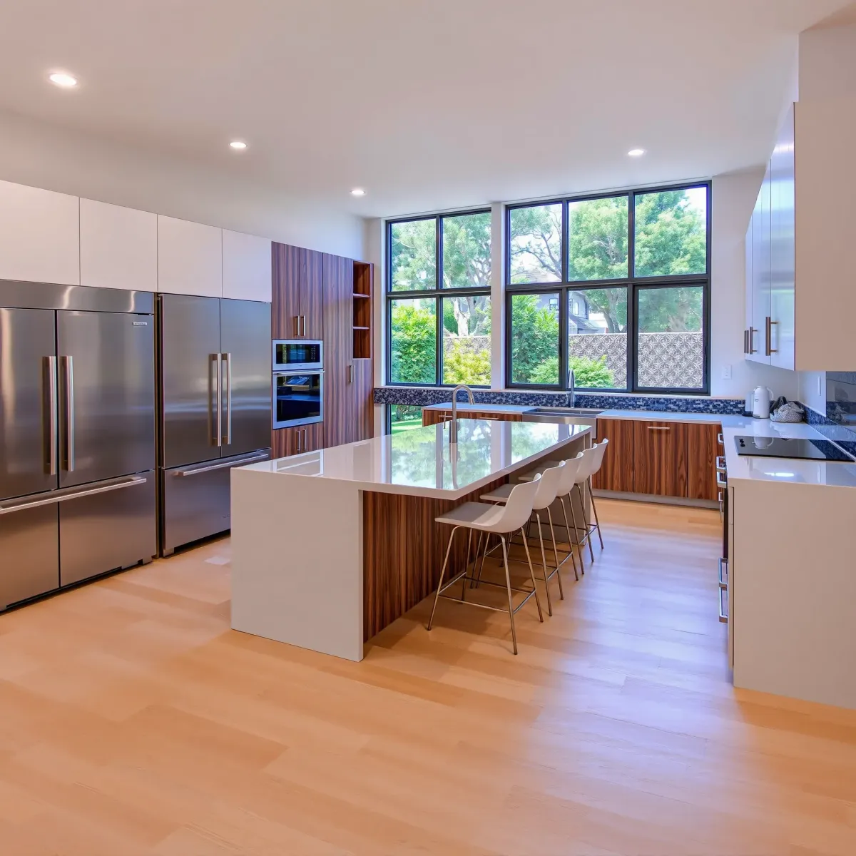 Modern Los Alamitos kitchen with quartz island, stainless appliances, wood accents, and abundant natural light.
