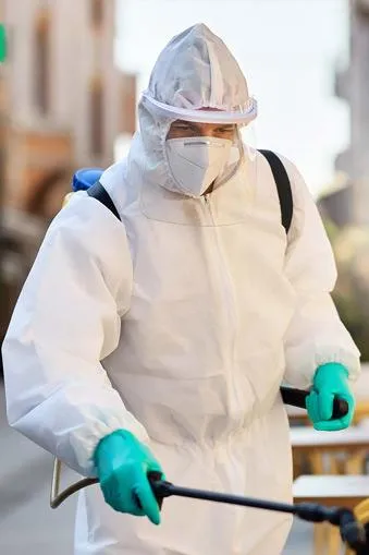 Vancouver pest control technician spaying inside a house for pests