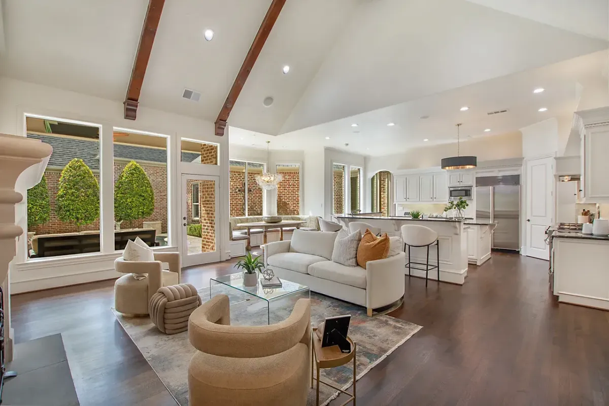 Open-concept living room and kitchen with a full wall of floor-to-ceiling windows, professionally staged by Model My Home—Dallas Fort Worth home staging and interior design experts.