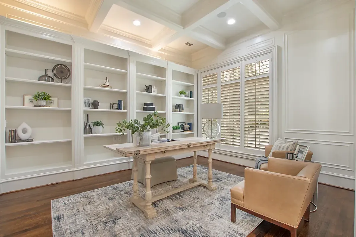 Cream colored office with large bookshelf wall.