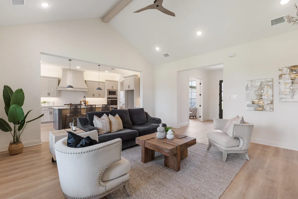 Modern staged living room with open kitchen design by Model My Home, professional home staging company in Dallas Fort Worth for real estate listings.