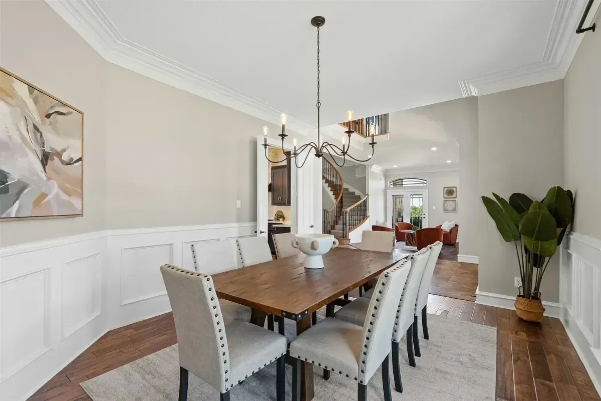 Cozy yet bright staged dining room with an eight-person dining table, located just off the kitchen and styled by Model My Home—Dallas Fort Worth home staging and design experts.