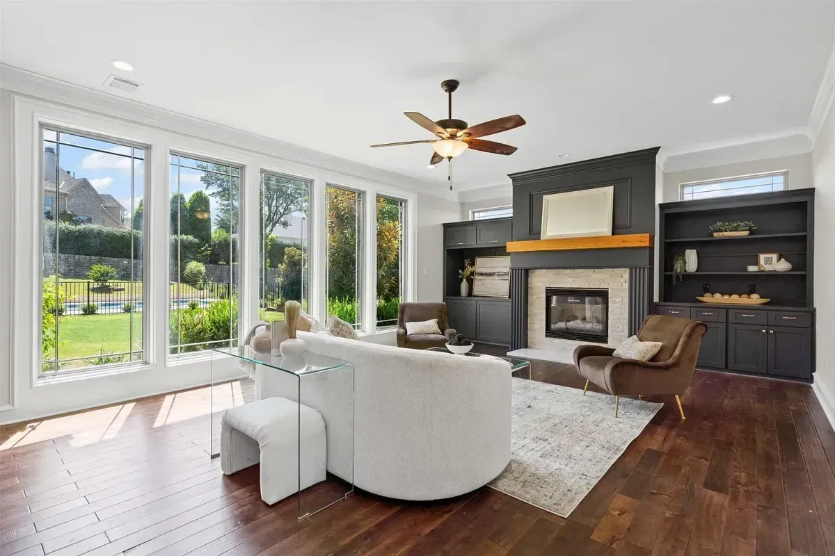 Staged living room featuring a full wall of windows overlooking the backyard and a stylish accent wall, professionally designed by Model My Home—Dallas Fort Worth home staging and interior design experts.