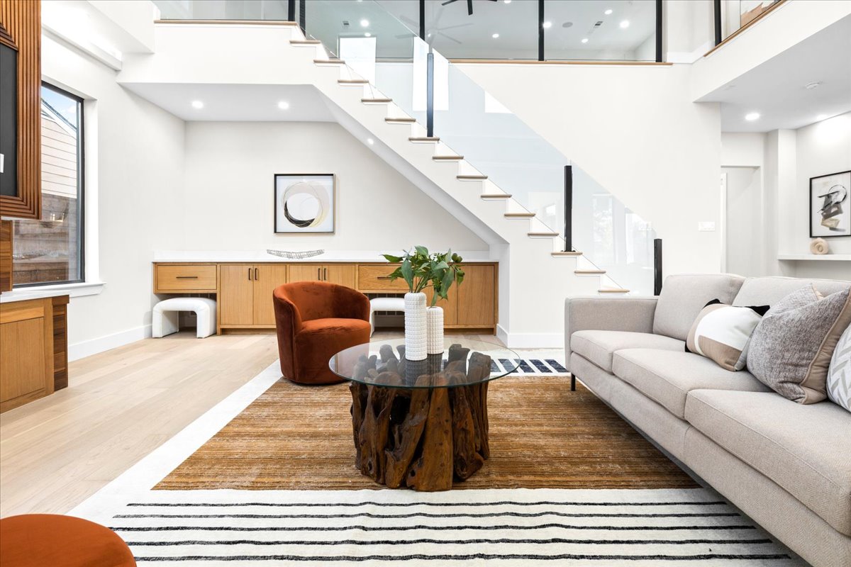 Luxury staged living room with abundant natural lighting, open-concept layout, and view to the upstairs loft, professionally styled by Model My Home—Dallas Fort Worth home staging and design experts.