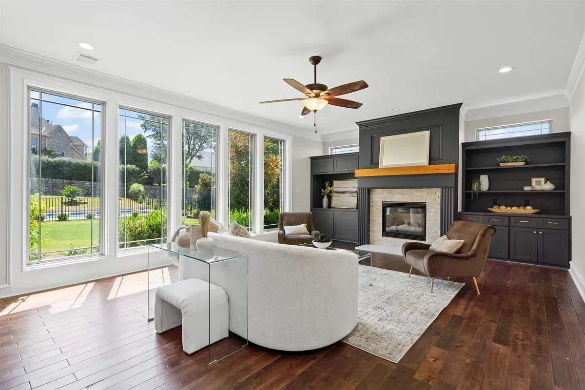 Staged living room featuring a full wall of windows overlooking the backyard and a stylish accent wall, professionally designed by Model My Home—Dallas Fort Worth home staging and interior design experts.