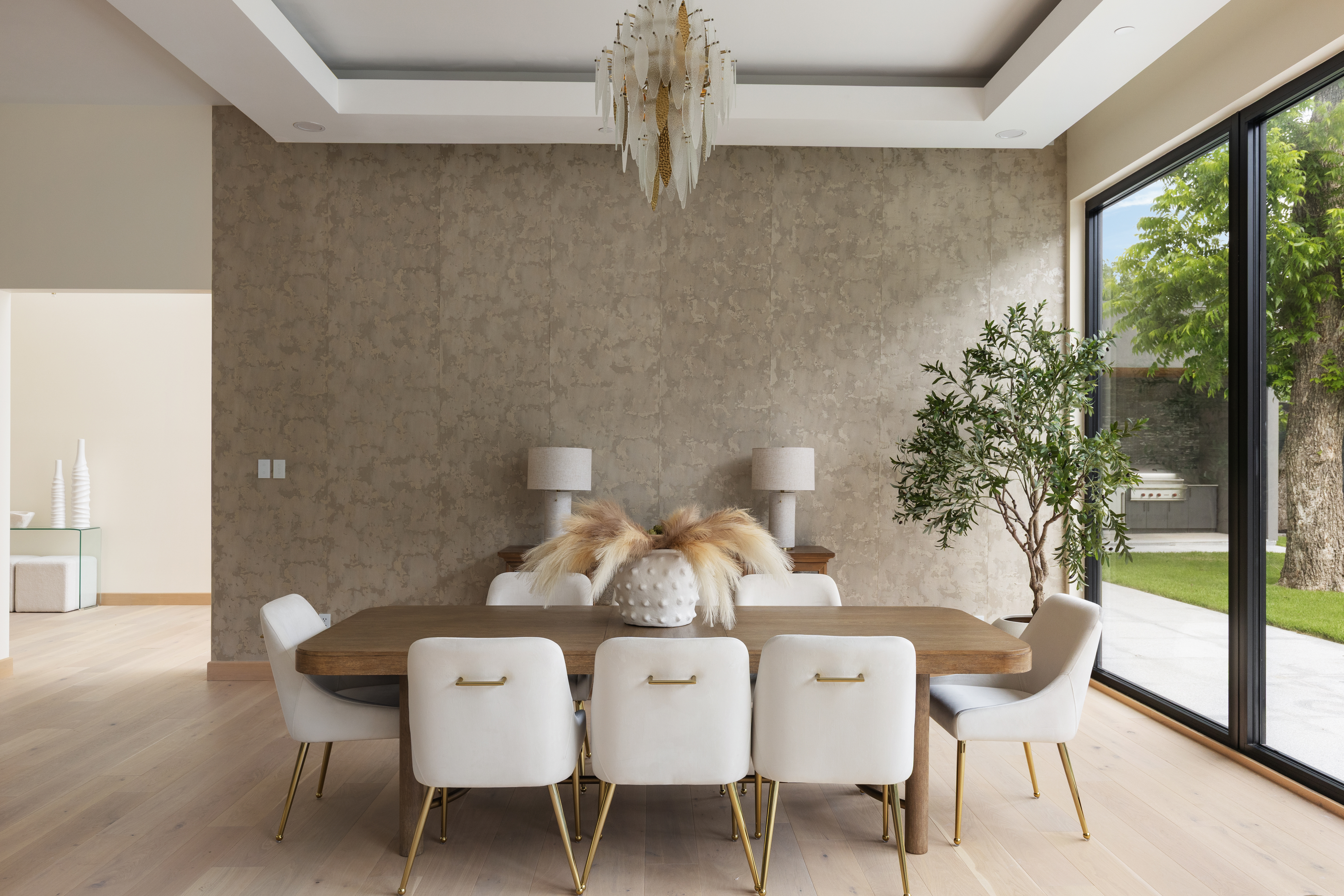 Open-concept dining room connected to the living room and kitchen, professionally staged by Model My Home—Dallas Fort Worth home staging and interior design experts.