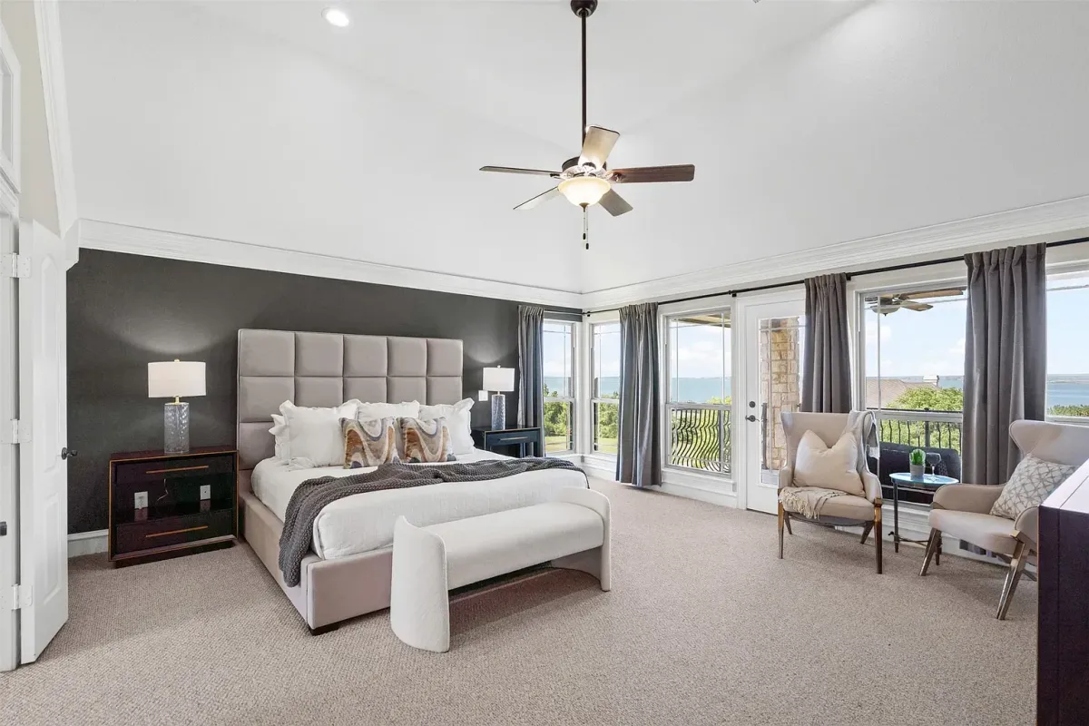 Spacious, bright primary bedroom with large windows and access to a private balcony, professionally staged by Model My Home—Dallas Fort Worth home staging and interior design experts.